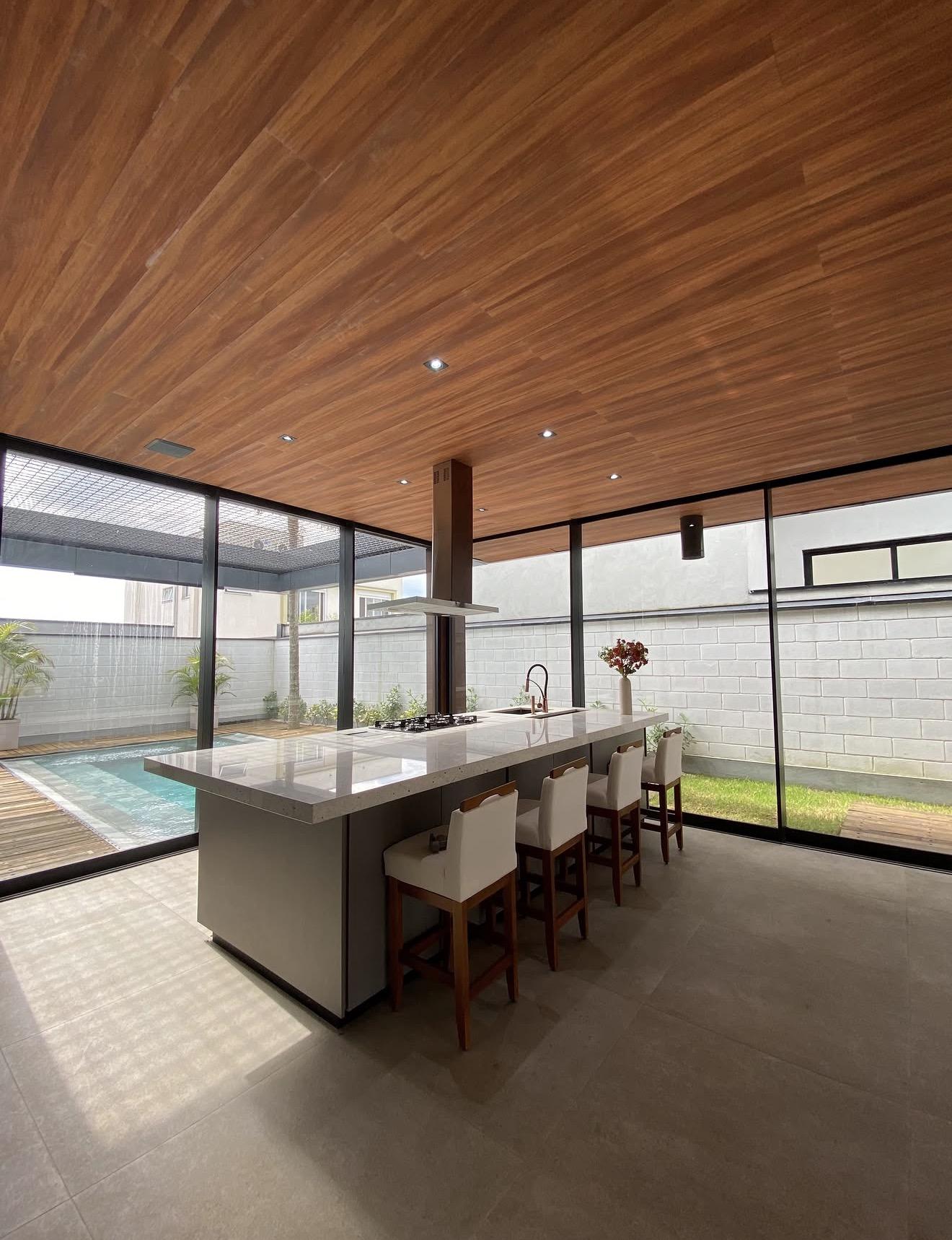 Ilha da cozinha com bancos e vista para a piscina
