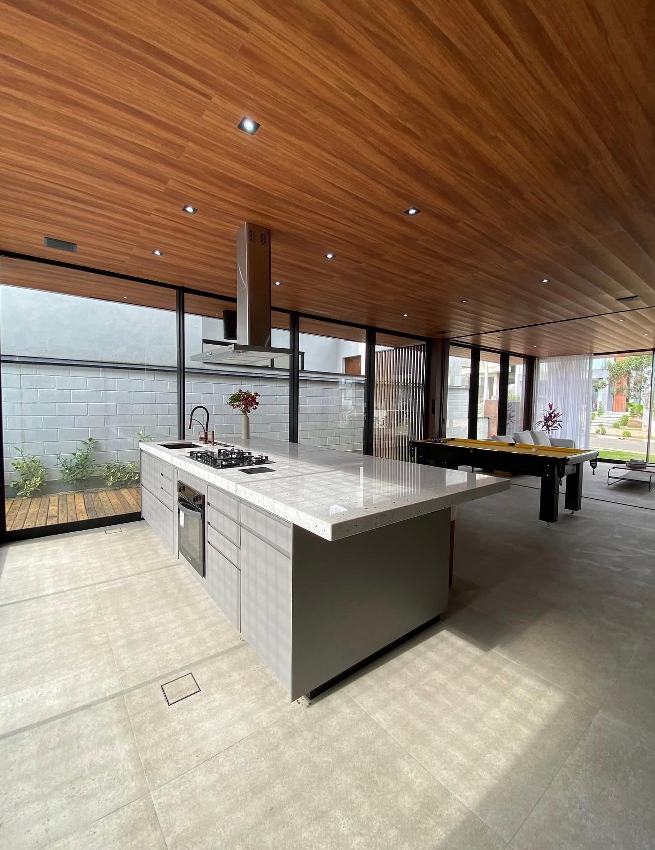 Cozinha integrada com ilha, coifa em aço inox e bancada em mármore Pitaya