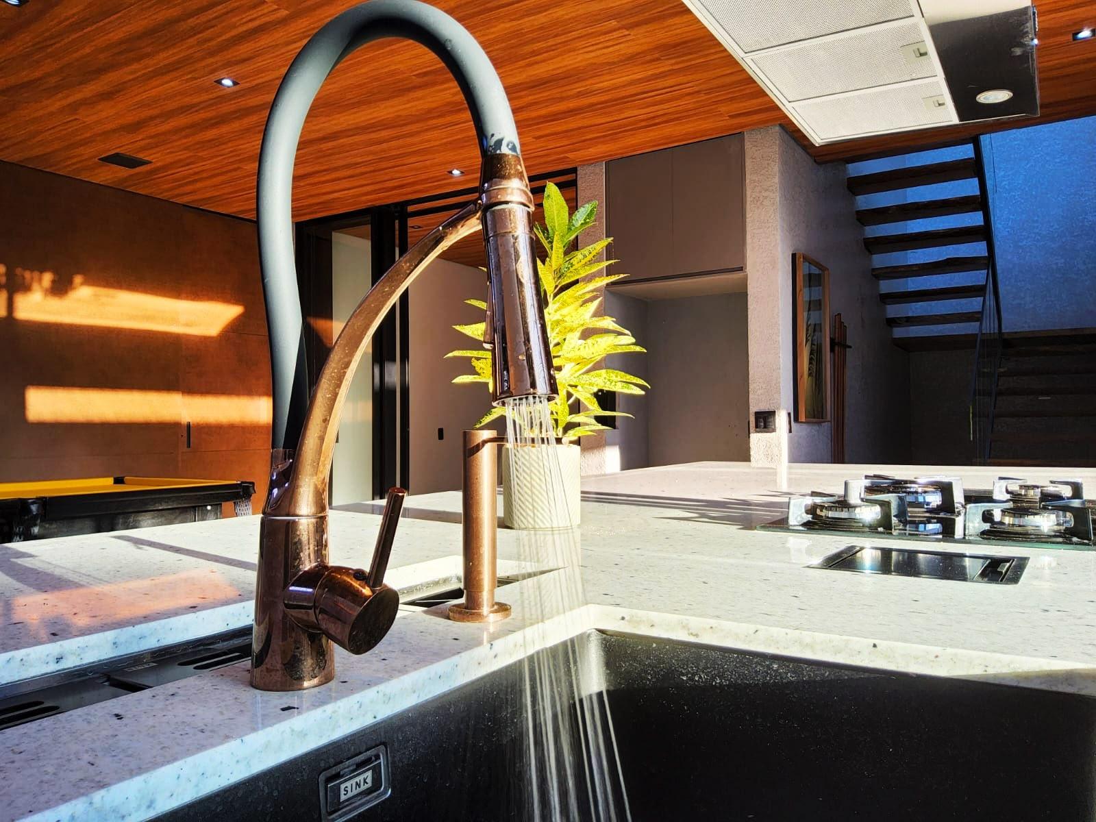 Detalhe da torneira, bancada em mármore Pitaya e cuba da cozinha