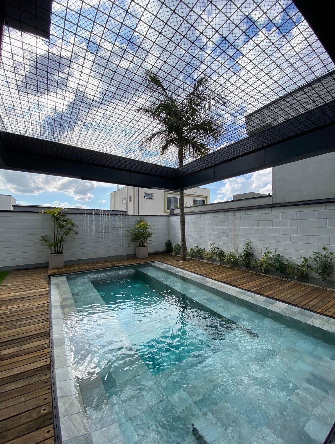 Piscina com prainha, deck e palmeira sob a rede